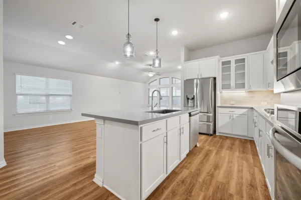 a kitchen with sink stove and refrigerator