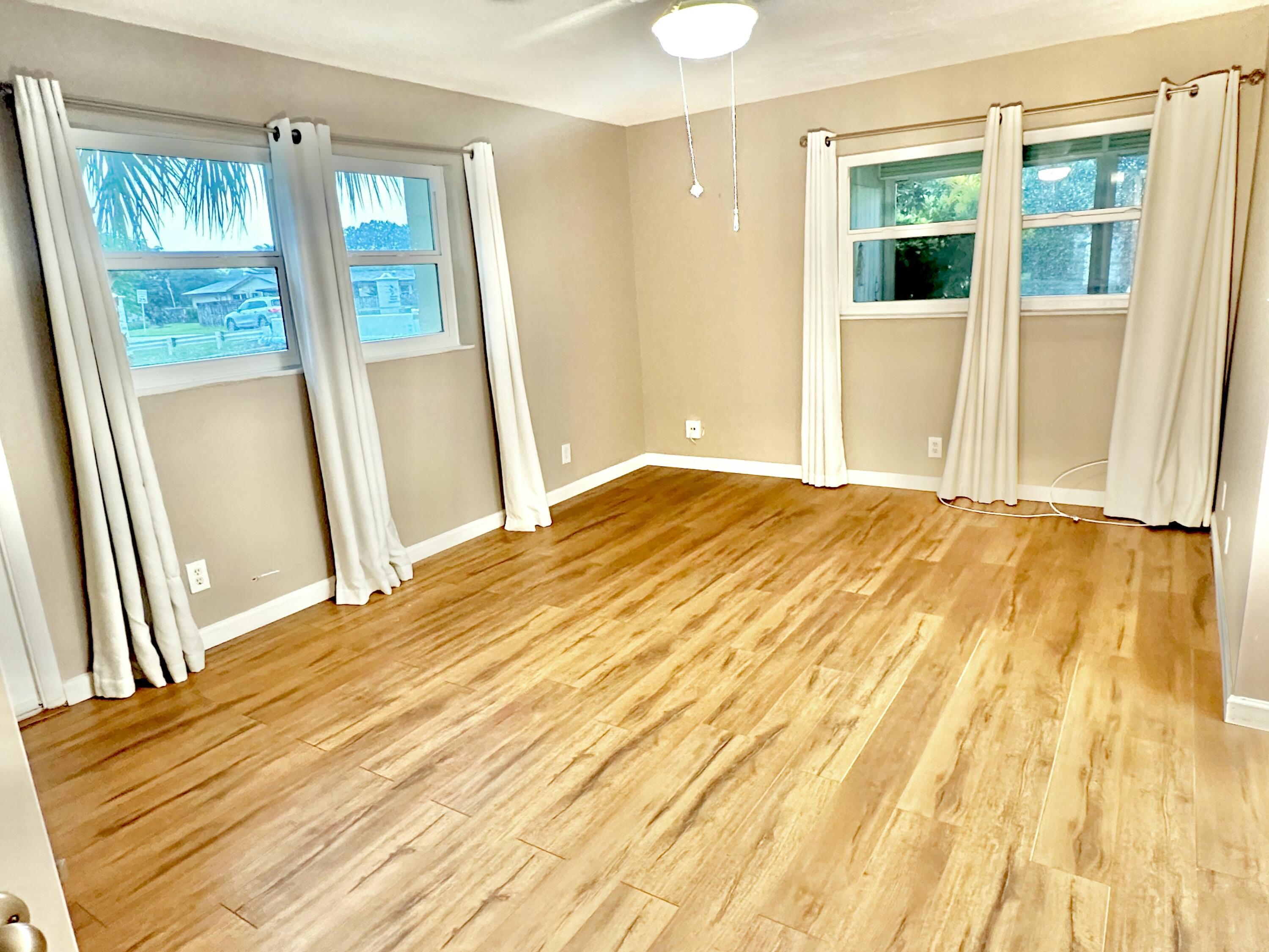 10821 North Military Trail, Unit 21 Palm Beach Gardens, FL 33410 - Photo 14 of 34 a bedroom with a bed and wooden floor