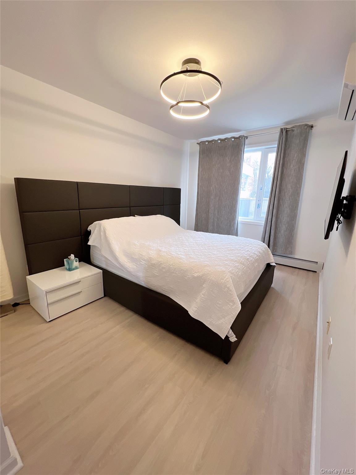 138-12 Northern Boulevard, Unit 3C Queens, NY 11354 - Photo 12 of 18 a bedroom with a bed and a chandelier