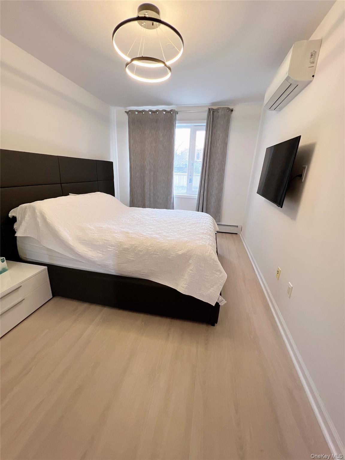 138-12 Northern Boulevard, Unit 3C Queens, NY 11354 - Photo 13 of 18 a bedroom with a bed and a flat screen tv