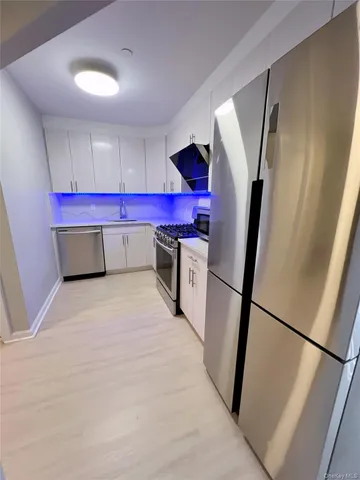 a room with microwave and a dresser