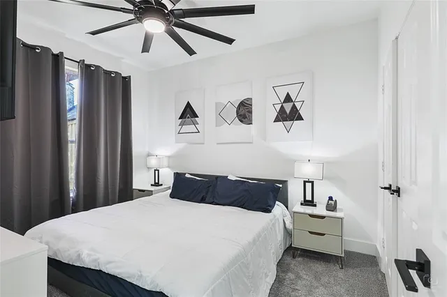 a living room with a dining table and a ceiling fan