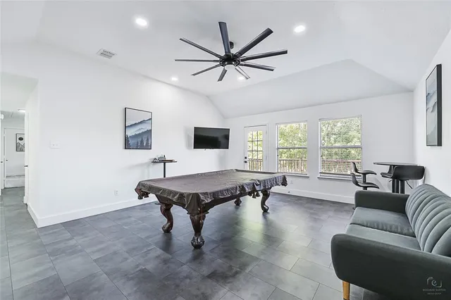 a kitchen with stainless steel appliances granite countertop a stove a sink a dining table and chairs with wooden floor