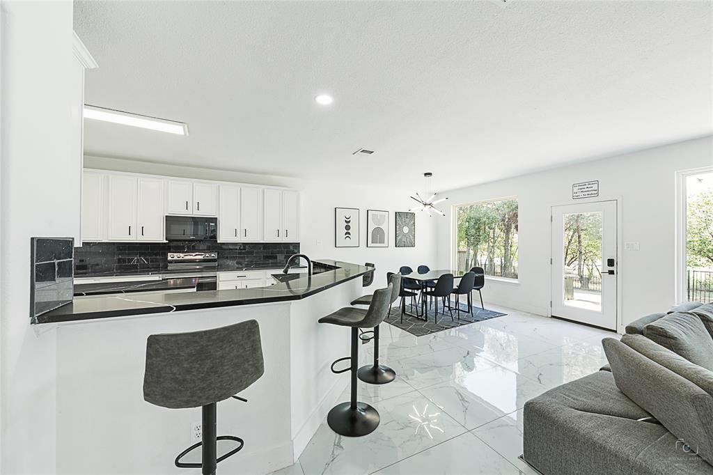 3805 Overlook Court The Colony, TX 75056 - Photo 17 of 29 a kitchen with stainless steel appliances granite countertop a stove a sink a dining table and chairs with wooden floor
