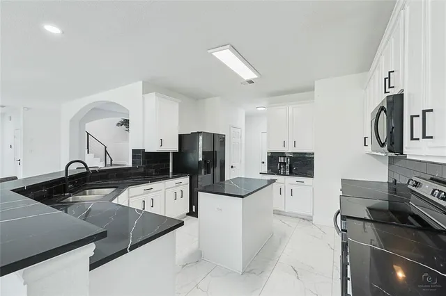 a kitchen with granite countertop white cabinets and white appliances