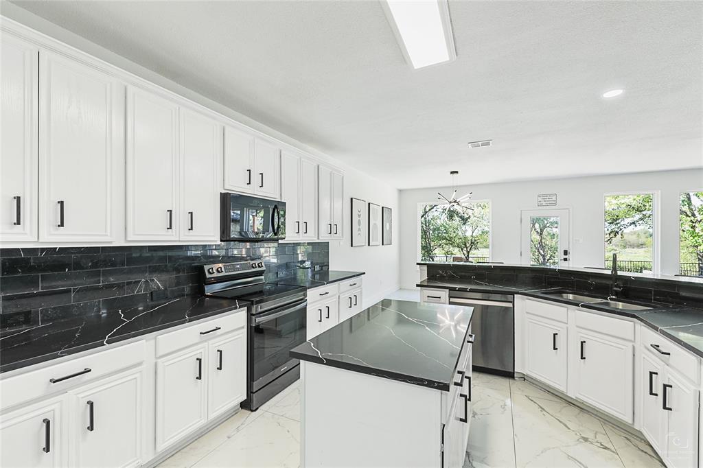 3805 Overlook Court The Colony, TX 75056 - Photo 29 of 29 a kitchen with granite countertop white cabinets and white appliances