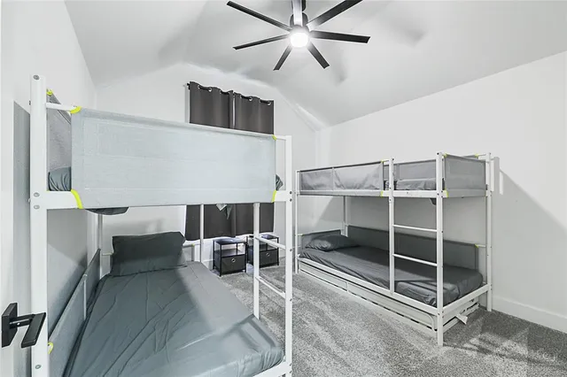 a living room with a dining table and paintings on the wall