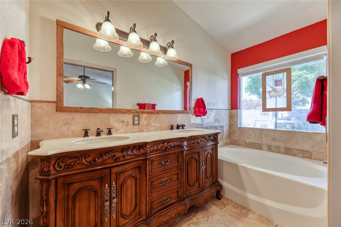 2001 Appaloosa Road Henderson, NV 89002 - Photo 33 of 44 This bathroom features a large vanity with double sinks, a soaking tub, and elegant tile work.