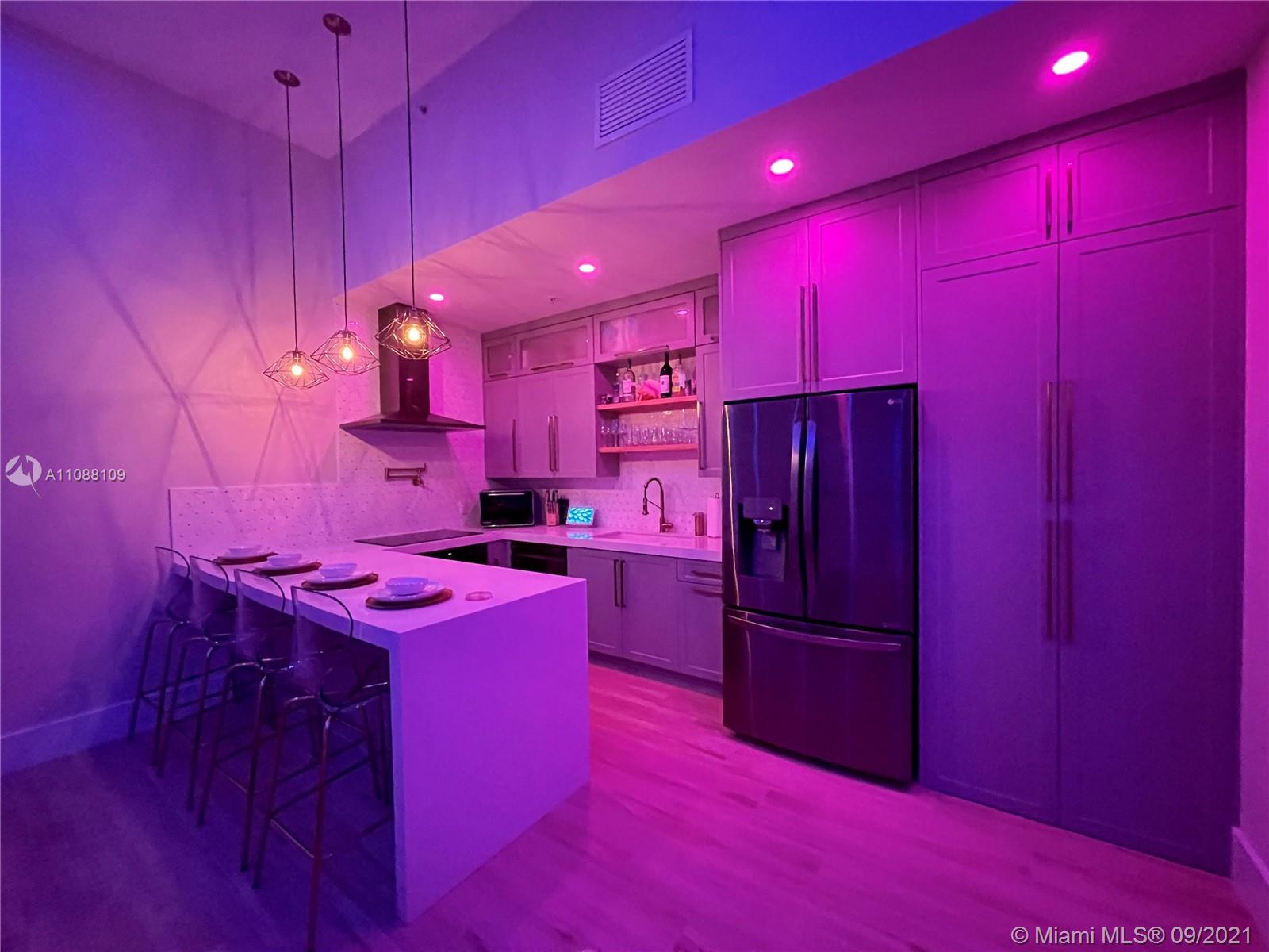 935 Euclid Avenue, Unit 5 Miami Beach, FL 33139 - Photo 11 of 27 a kitchen with red cabinets and stainless steel appliances