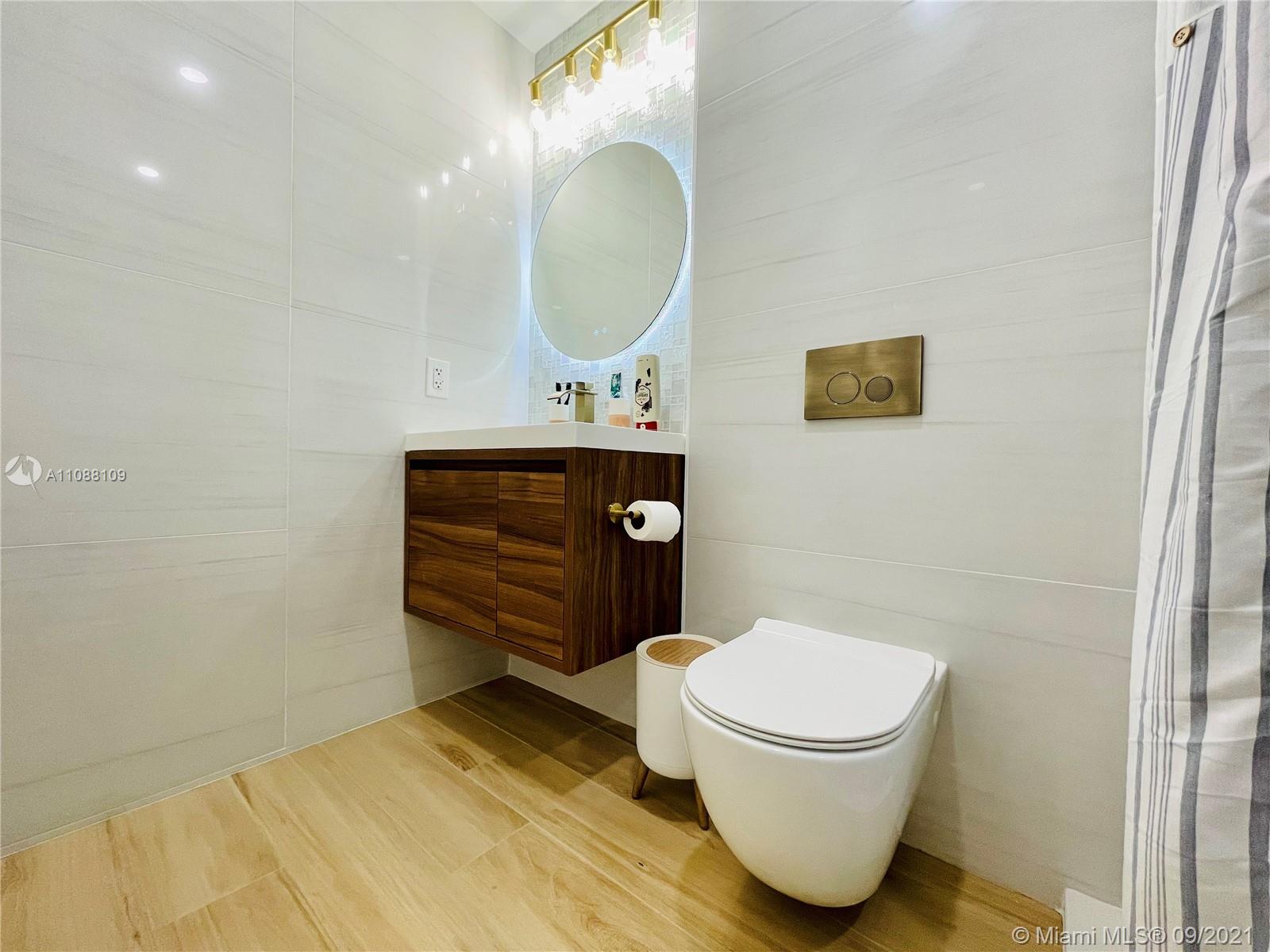 935 Euclid Avenue, Unit 5 Miami Beach, FL 33139 - Photo 14 of 27 a bathroom with a toilet a sink and mirror