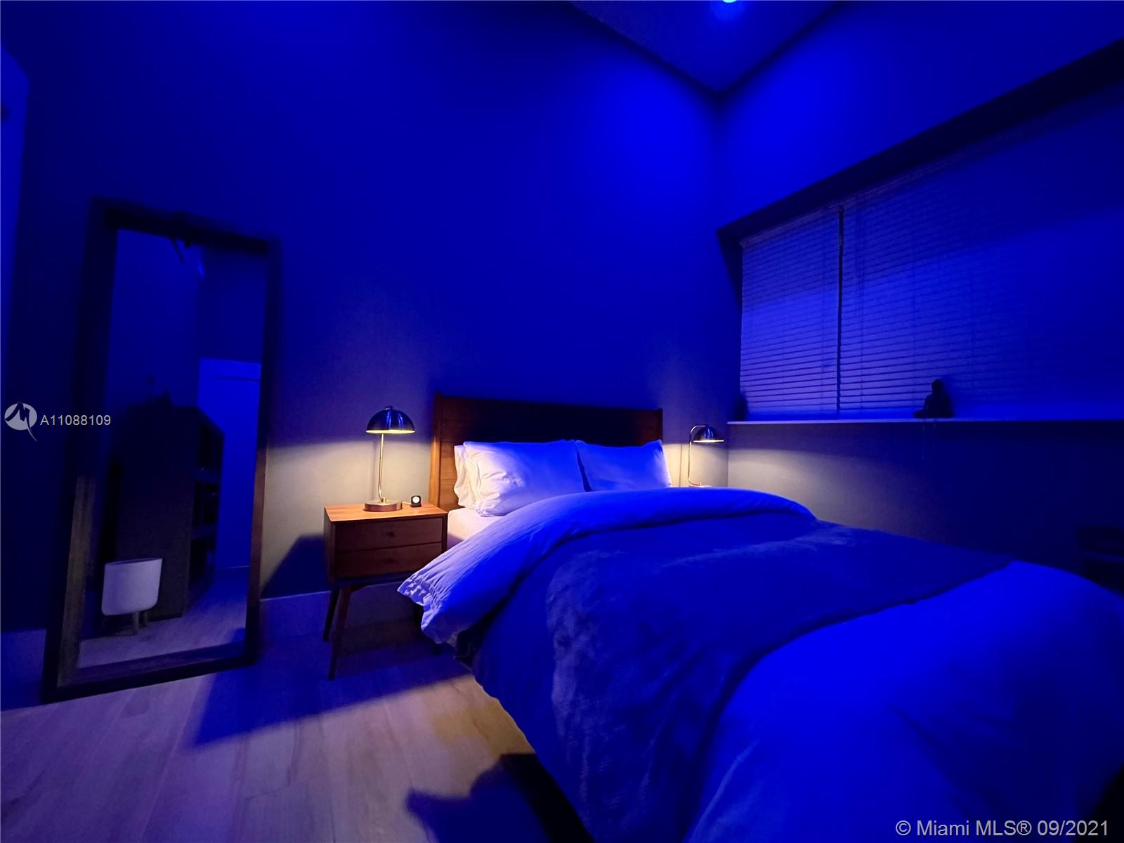 935 Euclid Avenue, Unit 5 Miami Beach, FL 33139 - Photo 23 of 27 a bed sitting in a bedroom next to a lamp