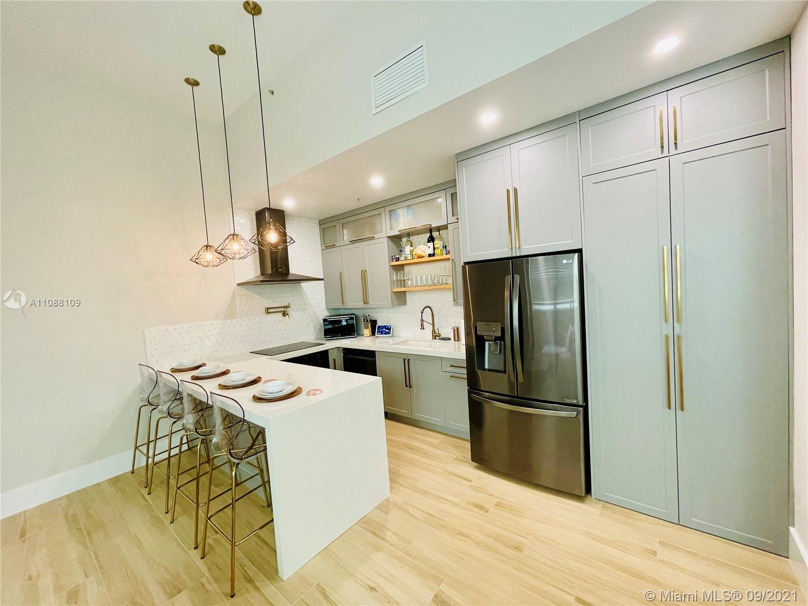 935 Euclid Avenue, Unit 5 Miami Beach, FL 33139 - Photo 10 of 27 a kitchen with stainless steel appliances granite countertop a refrigerator a stove a sink dishwasher and a refrigerator with wooden floor