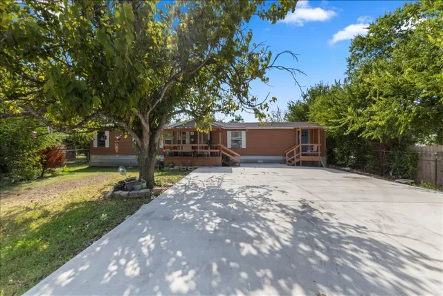 a view of a house with a yard and tree