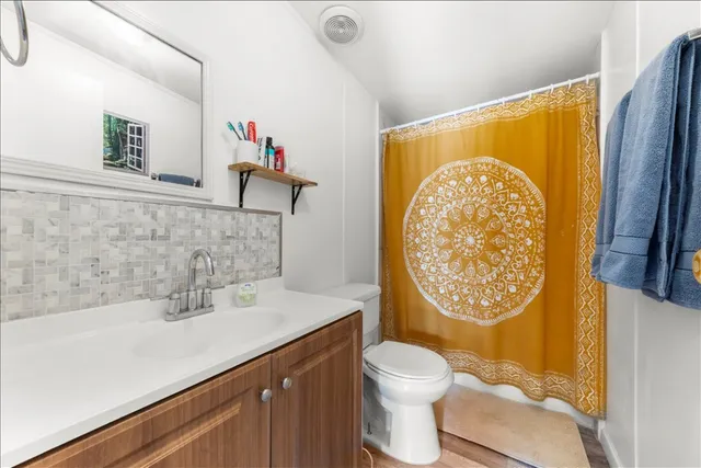 a bathroom with a sink mirror vanity and toilet