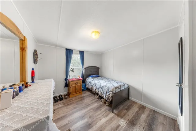 a bedroom with a bed and wooden floor