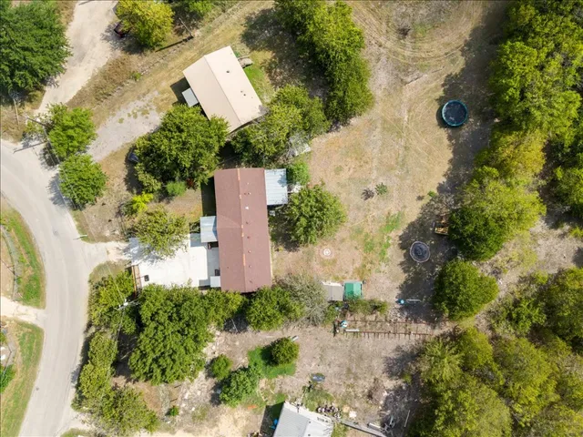 an aerial view of a house with a yard and a large tree