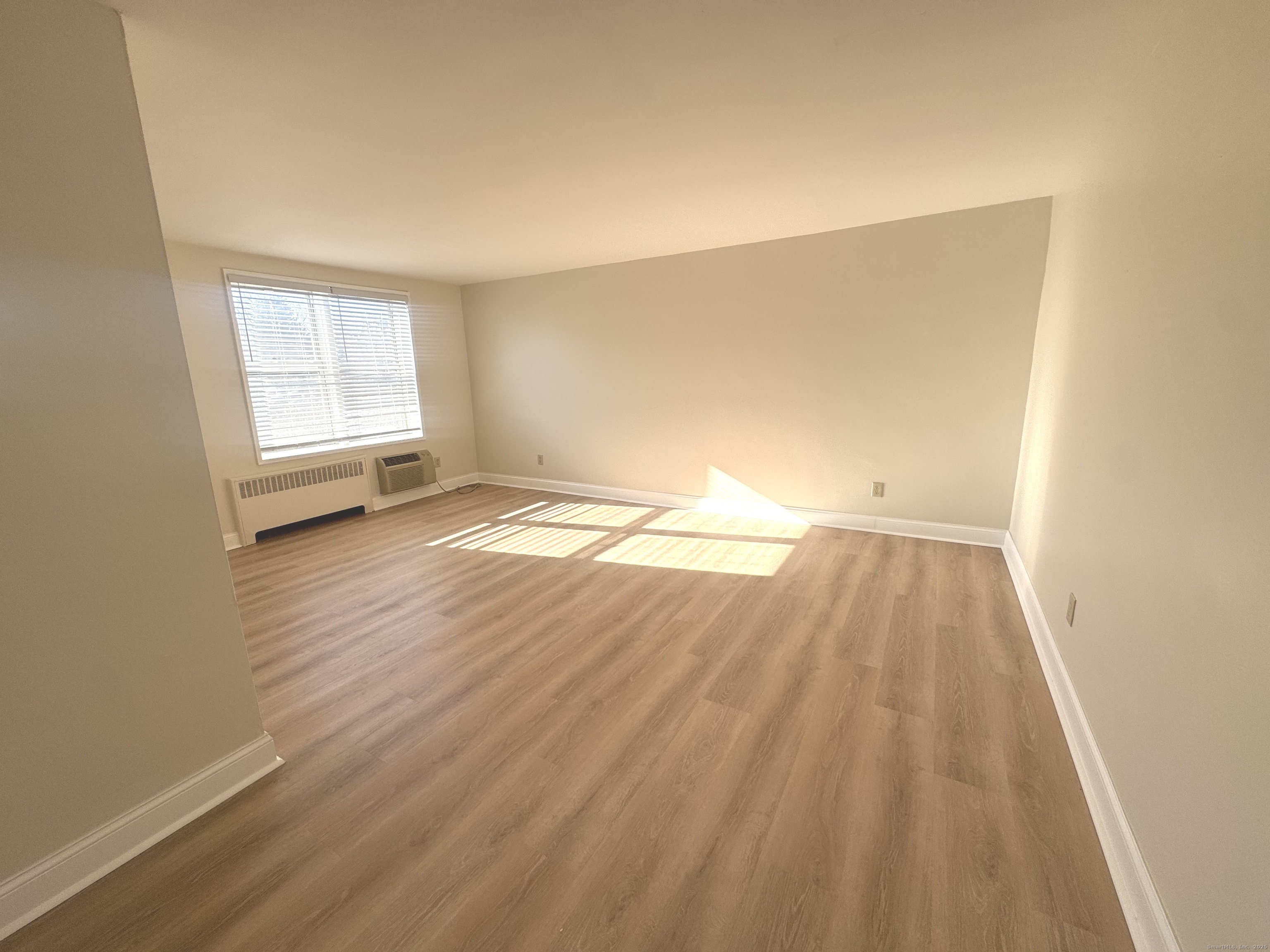 45 Maple Street, Unit 2E Norwalk, CT 06850 - Photo 4 of 16 a view of an empty room with wooden floor and a window