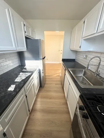 a kitchen with granite countertop a stove and a sink
