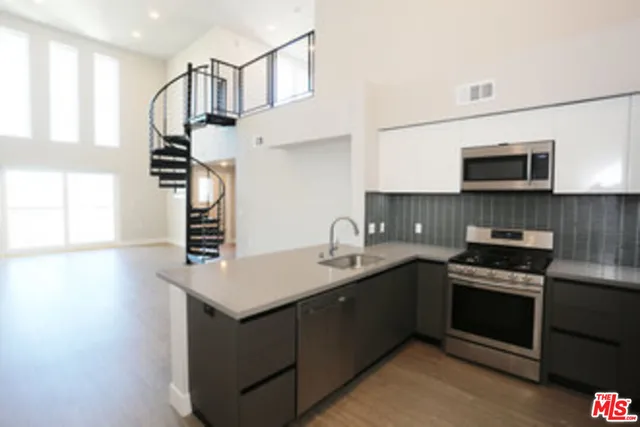 a kitchen with stainless steel appliances granite countertop a sink stove and microwave