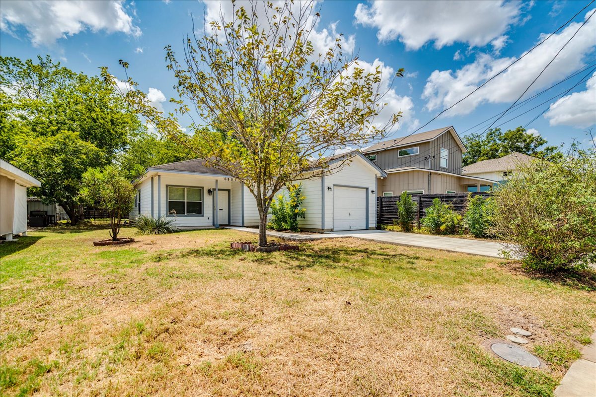 6801 Porter Street Austin, TX 78741 - Photo 29 of 30 A well-maintained single-story residence with an attached garage and a neatly kept lawn.