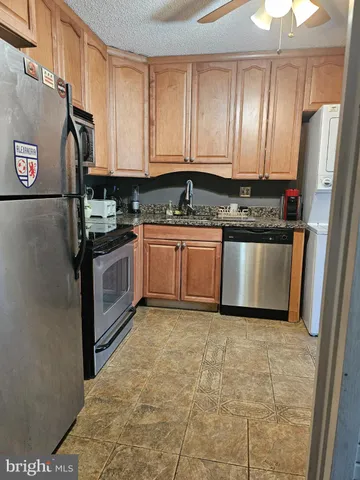 a kitchen with stainless steel appliances granite countertop a stove a sink and a refrigerator