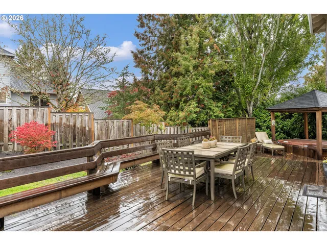 a roof deck with table and chairs and potted plants