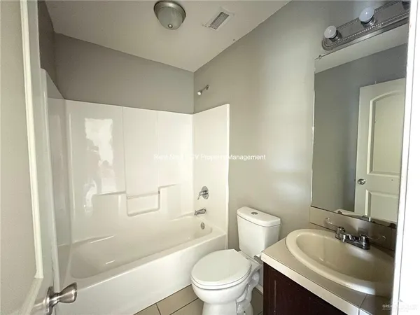 a bathroom with a granite countertop sink toilet a mirror and shower