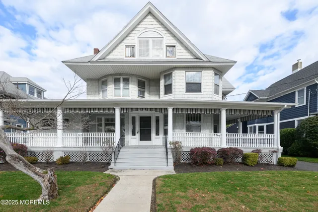 a front view of a house with a yard and potted plants