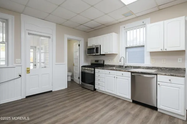 a kitchen with granite countertop white cabinets and white appliances
