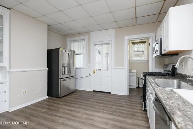 a kitchen with a refrigerator sink and cabinets