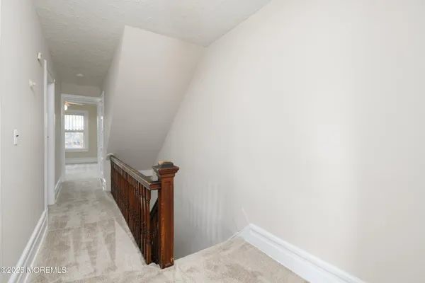 a view of a hallway with wooden floor and a door
