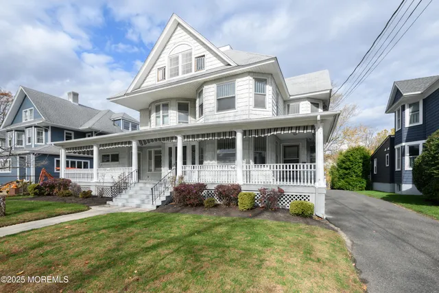 a front view of a house with a garden and trees