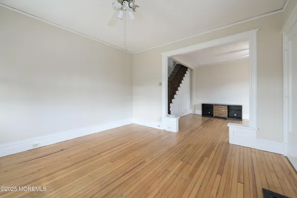 a view of empty room with wooden floor