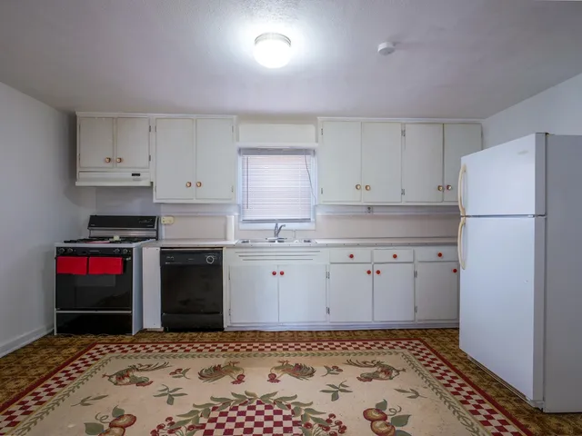 a kitchen with a stove and white cabinets