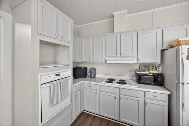 a kitchen with white cabinets and refrigerator