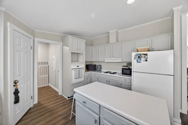 a kitchen with a refrigerator a stove top oven and white cabinets