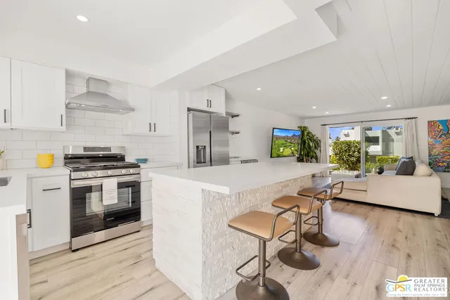 a kitchen with a stove a refrigerator and furniture