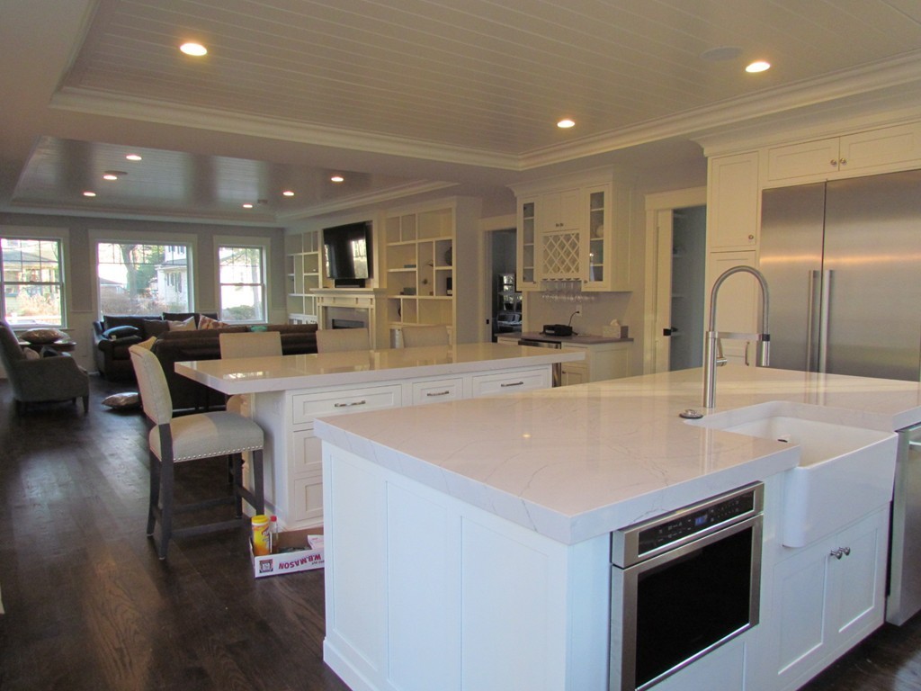 135 Maple Street, Unit 135 Needham, MA 02492 - Photo 4 of 13 a large kitchen with kitchen island a sink a stove a dining table and chairs