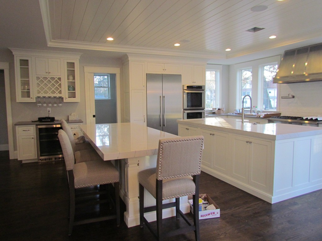 135 Maple Street, Unit 135 Needham, MA 02492 - Photo 5 of 13 a kitchen with a dining table chairs and refrigerator