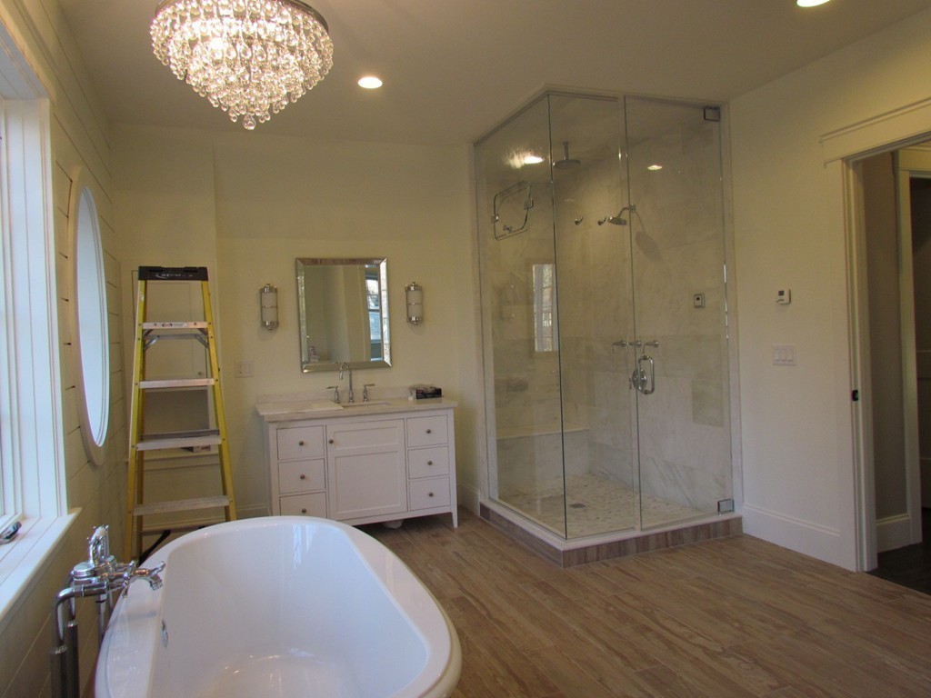 135 Maple Street, Unit 135 Needham, MA 02492 - Photo 10 of 13 a spacious bathroom with a granite countertop sink a mirror and a shower