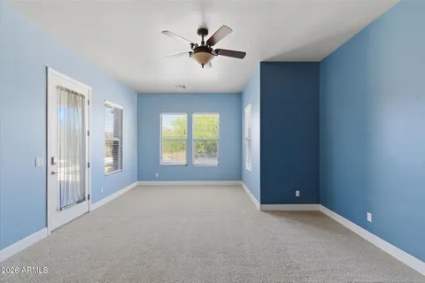an empty room with fan and windows