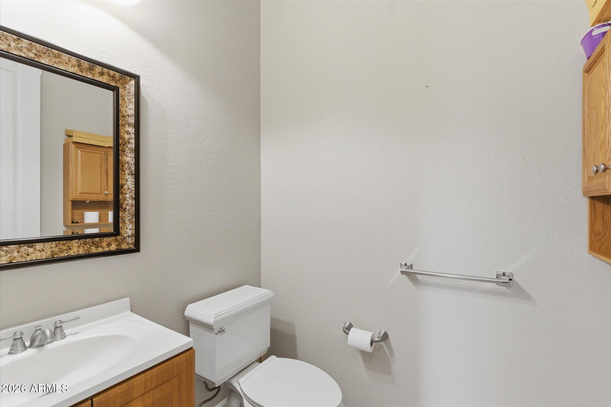 6914 West Fremont Road Laveen, AZ 85339 - Photo 26 of 32 a white toilet sitting next to a bathroom sink