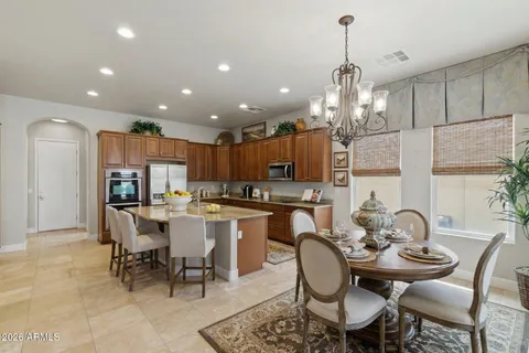 a dining room filled chandelier and kitchen view