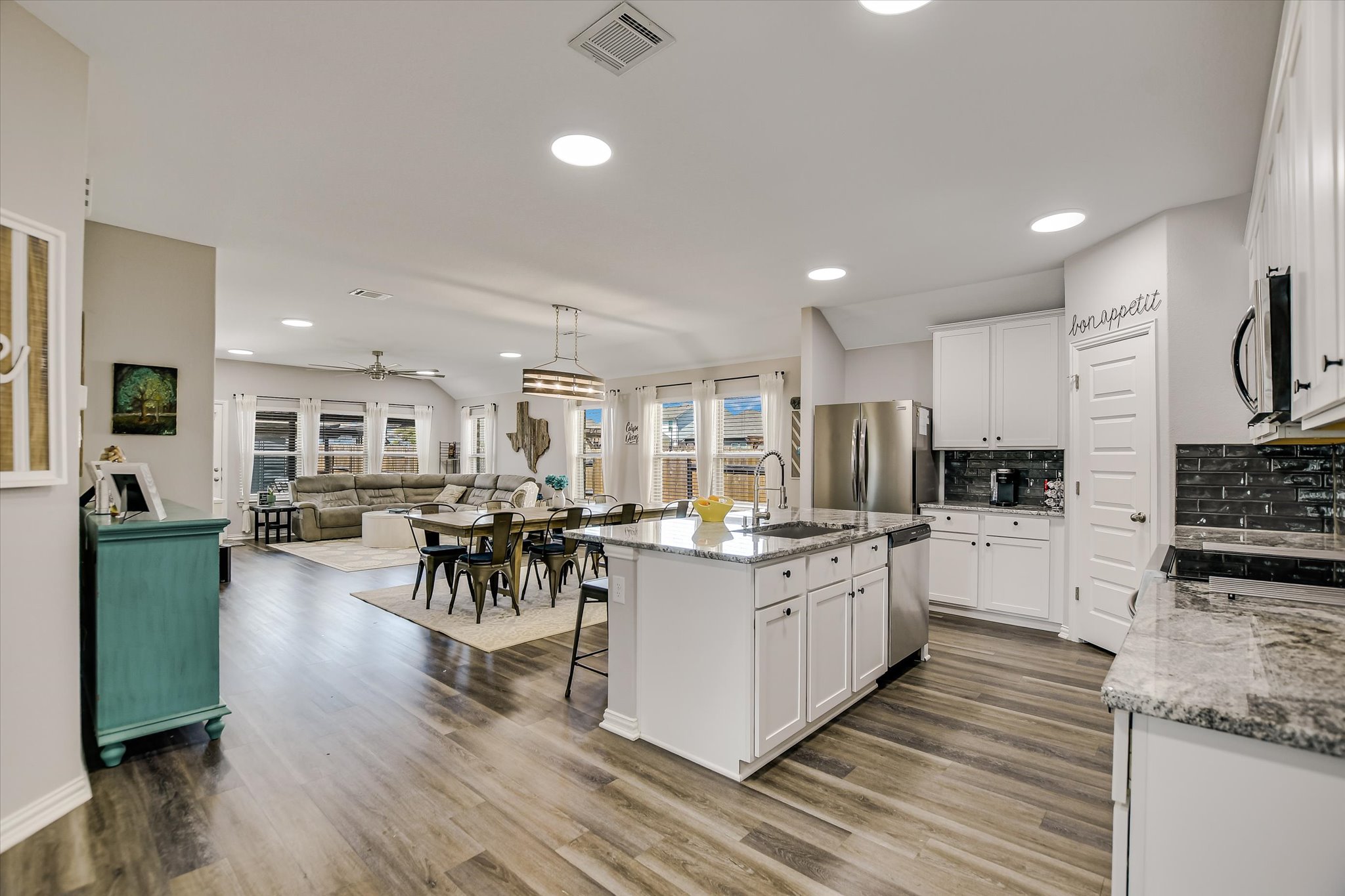 1101 Terrace View Drive Georgetown, TX 78628 - Photo 20 of 20 Kitchen featuring open floor plan, light stone countertops, white cabinets, a center island with sink, and a kitchen breakfast bar
