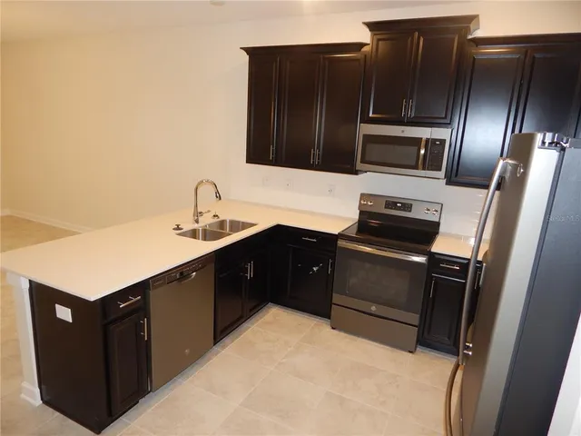 a kitchen with stainless steel appliances a sink and a refrigerator