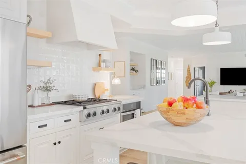 a kitchen with stainless steel appliances kitchen island granite countertop a sink and a stove