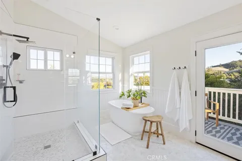 a bathroom with a double vanity sink mirror and bathtub