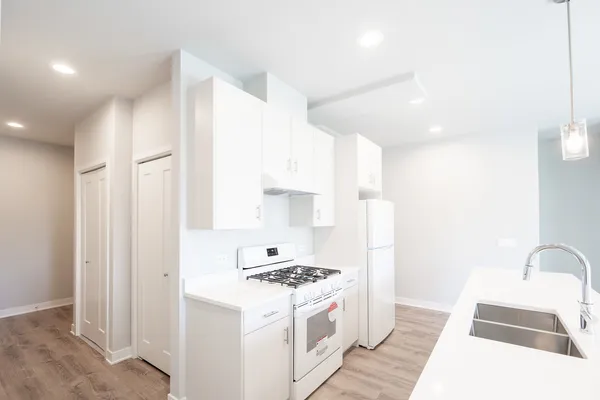 a kitchen with stainless steel appliances granite countertop a sink stove and refrigerator