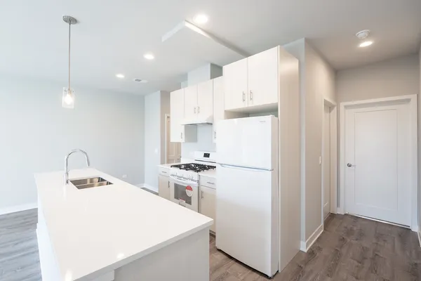 a kitchen with stainless steel appliances a refrigerator sink and white cabinets