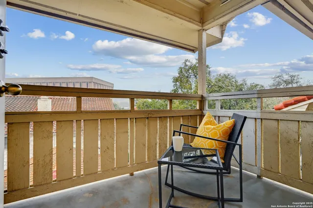 a view of a balcony with chair and glass door